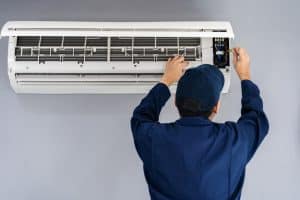 Back of technician working on wall mounted air conditioner